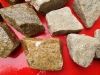 Kamień do gabionów, żółty drobnoziarnisty polski granit, (przykład). Kamień w stanie mokrym (po lewej) i suchym (po prawej)