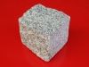 Kostka granitowa, cięto-łupana (przynajmniej jedna powierzchnia cięta). Polski granit, szary średnioziarnisty